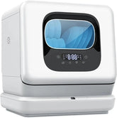 Countertop dishwasher on white background with door open revealing rack setup