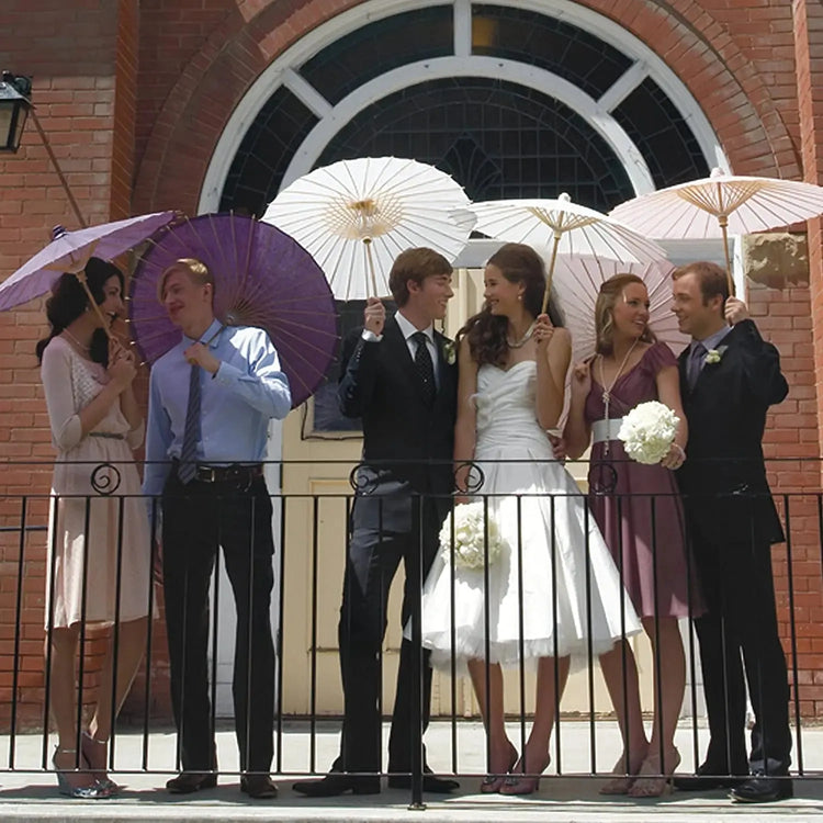 Guests holding drinks with paper parasol decorations at a backyard barbecue